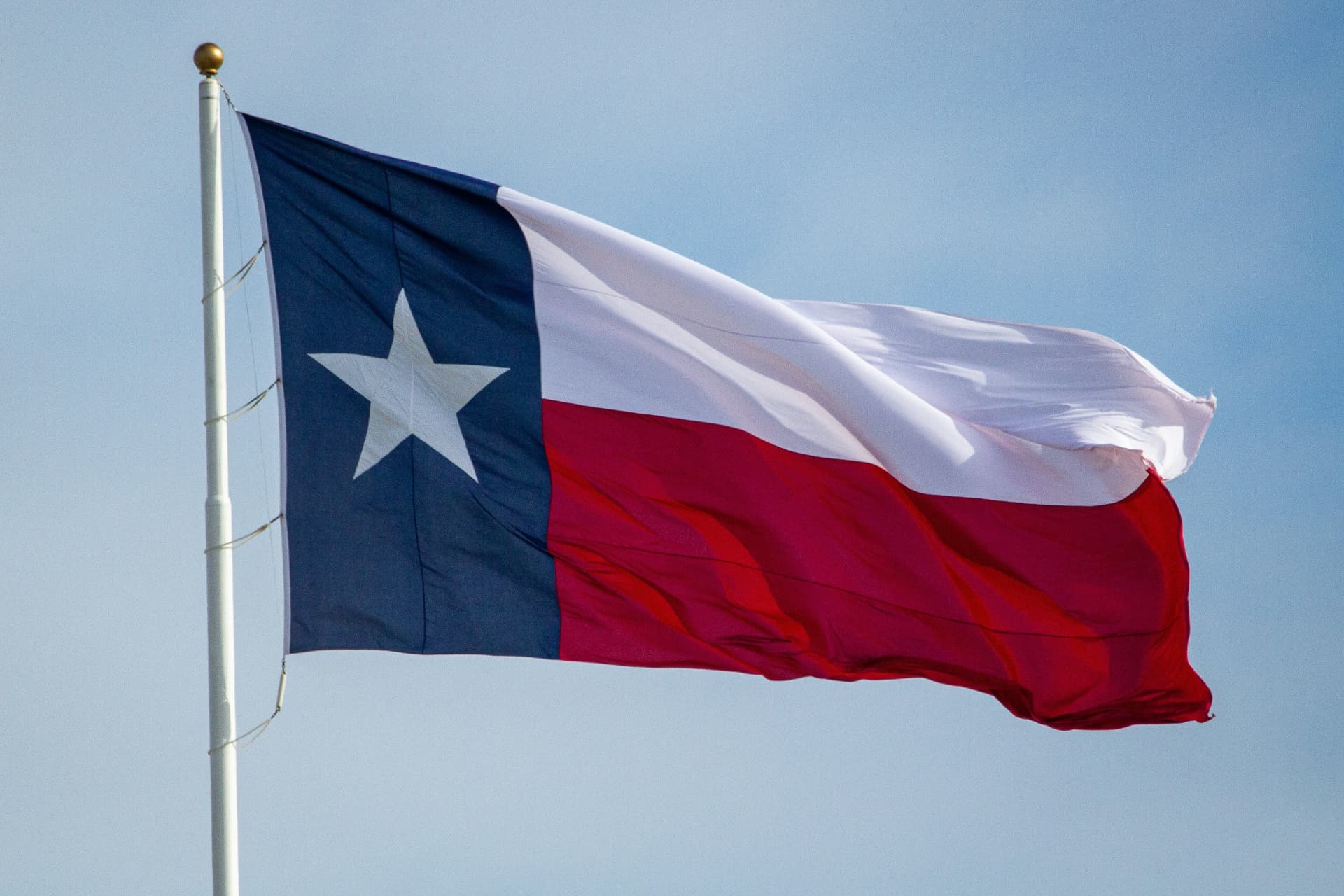 Texas state flag waving against a blue sky
